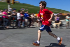 A young runner is seen running with the camera panning to follow their motion