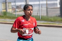 A runner splashes their head with water