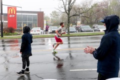 A man is seen running uphill next to volunteers
