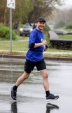 A man smiles to the camera while running
