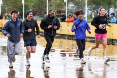 A group of runners smile as they run