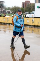 A man with Nordic walking poles smiles as they walk