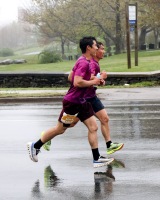 A pair of runners are in mid air with their strides nearly mirroring each other