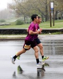 A pair of runners are in mid air with their strides nearly mirroring each other