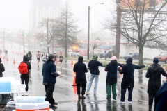 A group of volunteers are seen cheering on and waiting to hand out drinks to runners