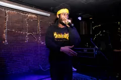 A man gestures to the crowd while rapping