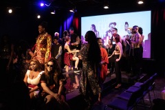 The models and designers on the stage at the end of Art Arena Project looking happy and accomplished