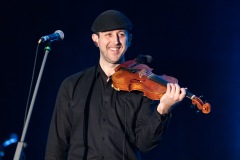 A violinist smiles at the crowd