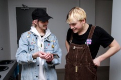 A man showing something on his phone to another person and the two are clearly enthusiastic about what they see.