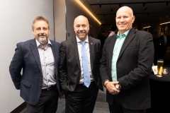 Three people in suits standing next to each other