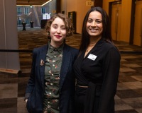 A staff member and attendant smile at the camera