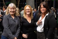 Three attendants smile to the camera