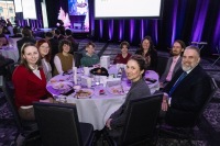 A group sitting at a table smiles towards the camera