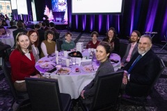 A group sitting at a table smiles towards the camera