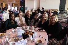 A group sitting at a table smiles towards the camera