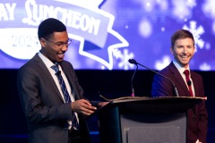 Two people at the podium smile to the crowd