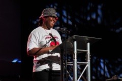 A woman smiles while speaking at the podium