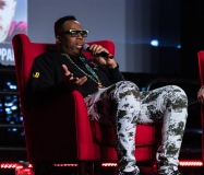 A man gestures while speaking on stage