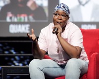 A woman gestures while speaking on stage