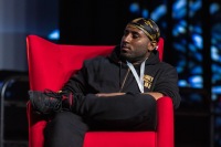 A man crosses their legs while listening on stage
