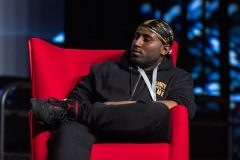 A man crosses their legs while listening on stage